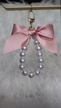 Pearl earring with a pink bow on a gold stand