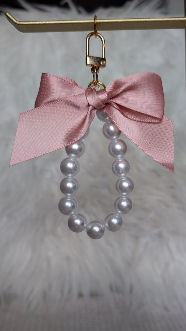 Pearl earring with a pink bow on a gold stand