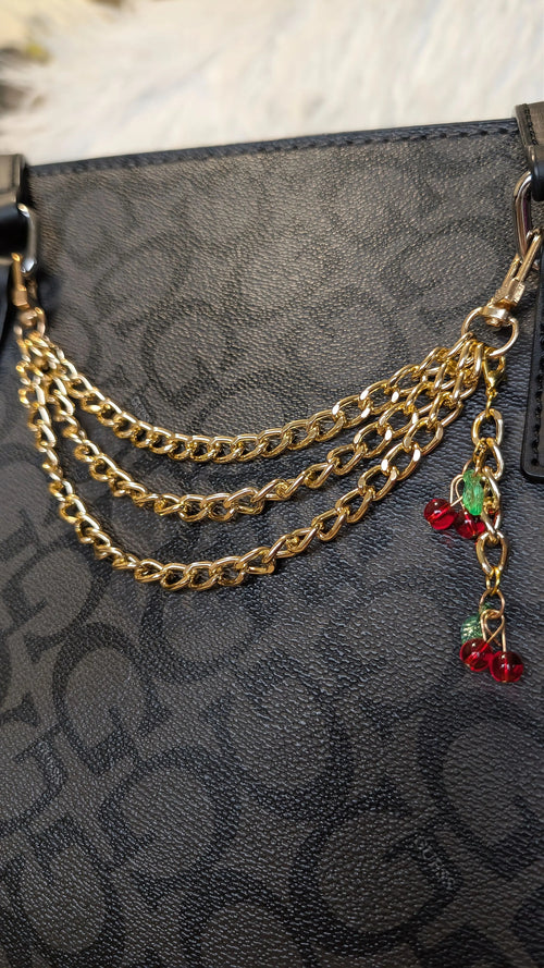 Gold chain accessory on a black textured surface