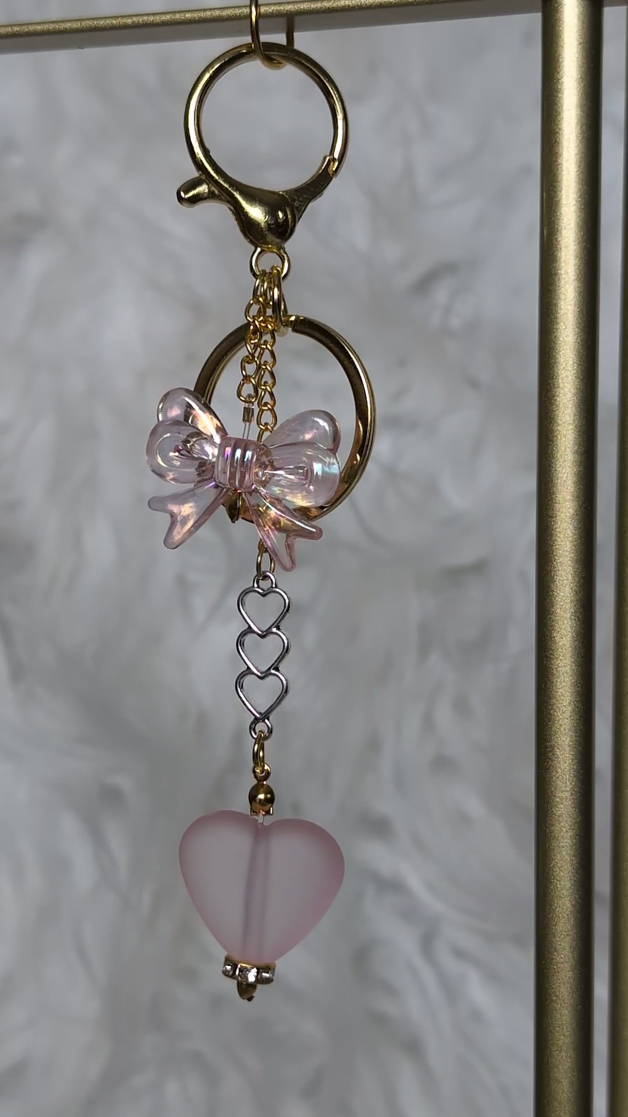 Keychain with pink butterfly and heart charm on a textured background